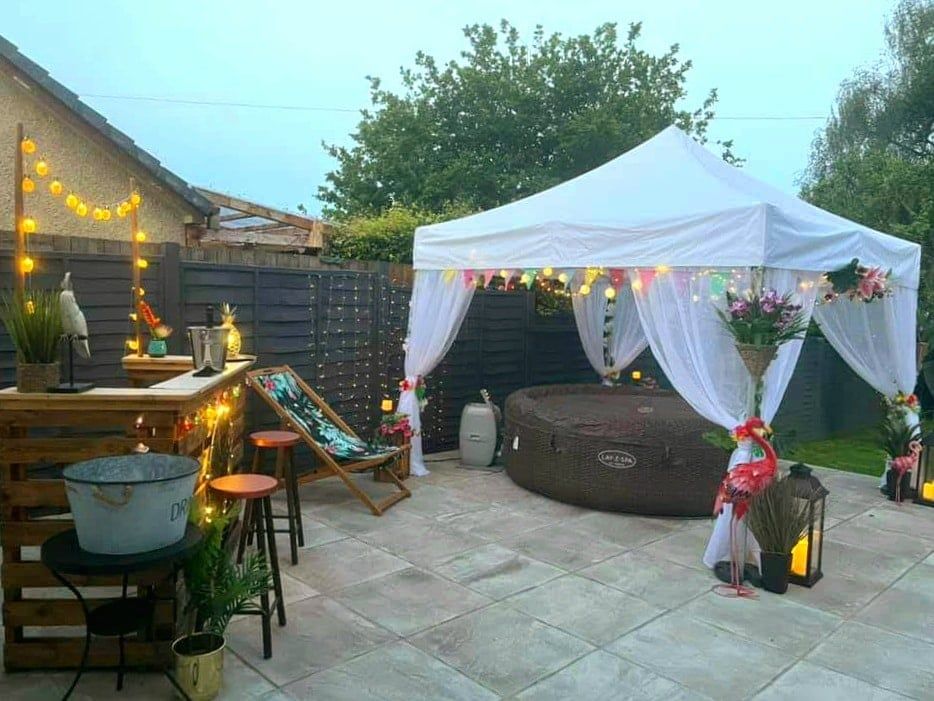 an white gazebo covering an outdoor hot tub