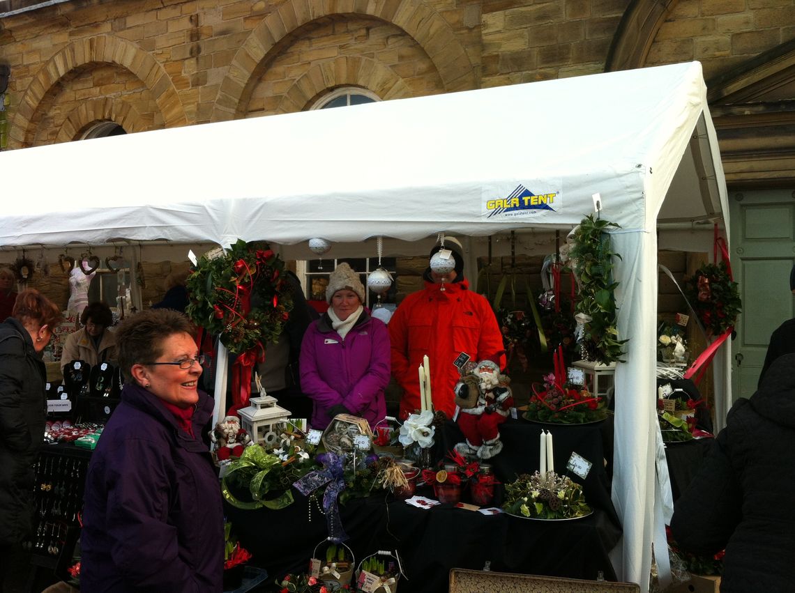 A marquee being used as shelter while selling Christmas products at a market