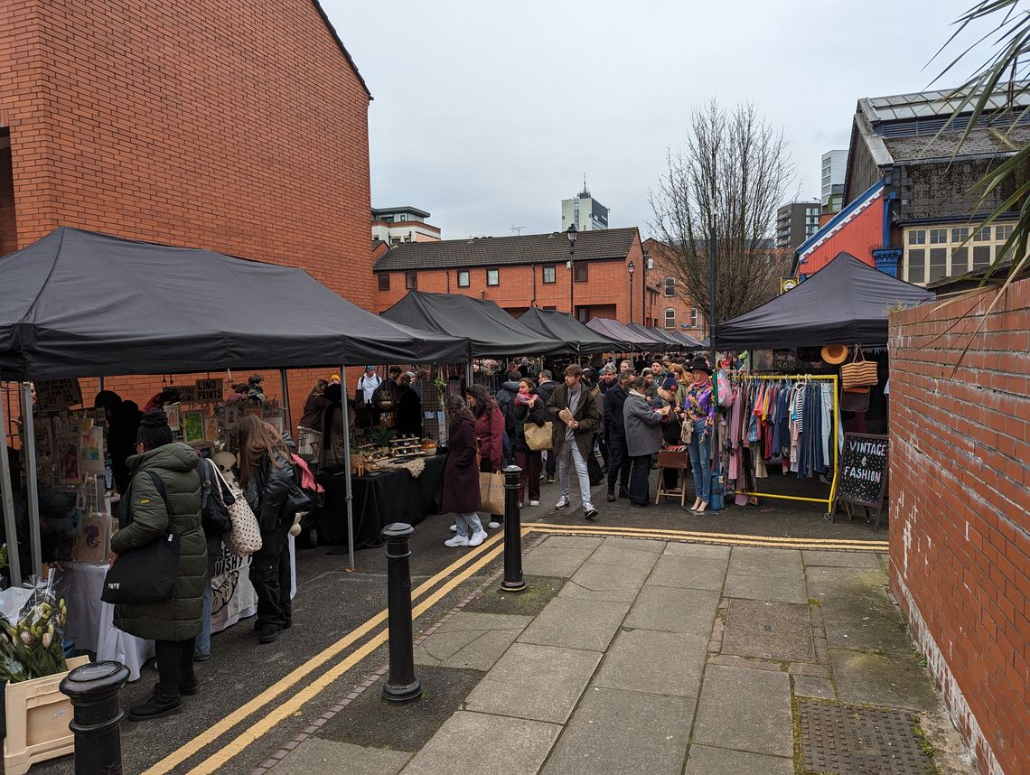 Two Manchester Markets black pop up gazebo stalls in action