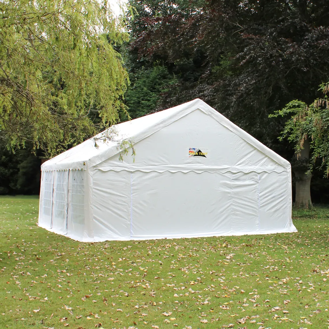 A 6m x 6m Marquee in a green space surrounded by trees