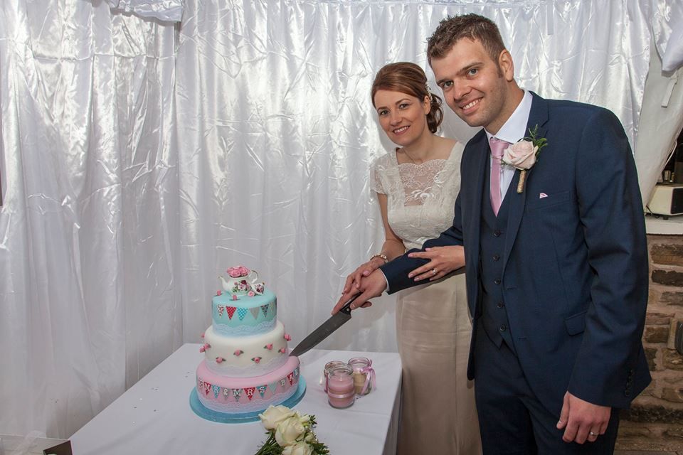 Happy couple cutting a cake in a marquee