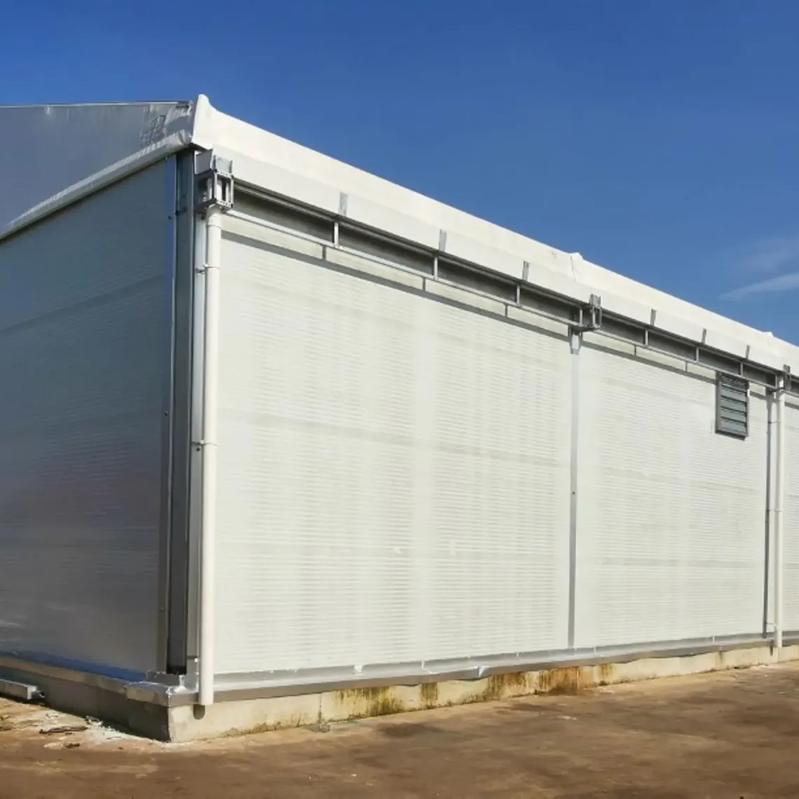 An industrial storage tent with blue sky behind it