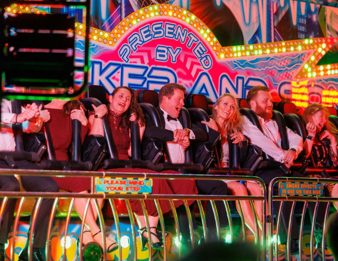 Smartly dressed revellers on a fair ground ride