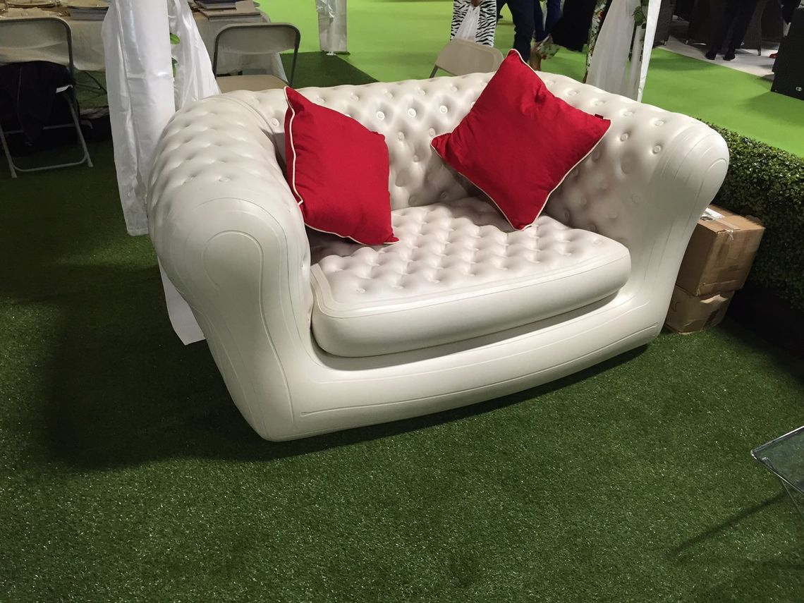 A white inflatable sofa with red cushions