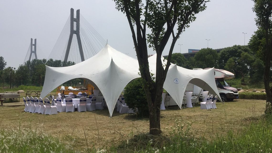 A large stretch tent capri marquee with a bridge in the background