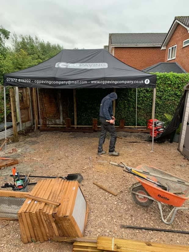 A weatherproof work tent with construction employee beneath it