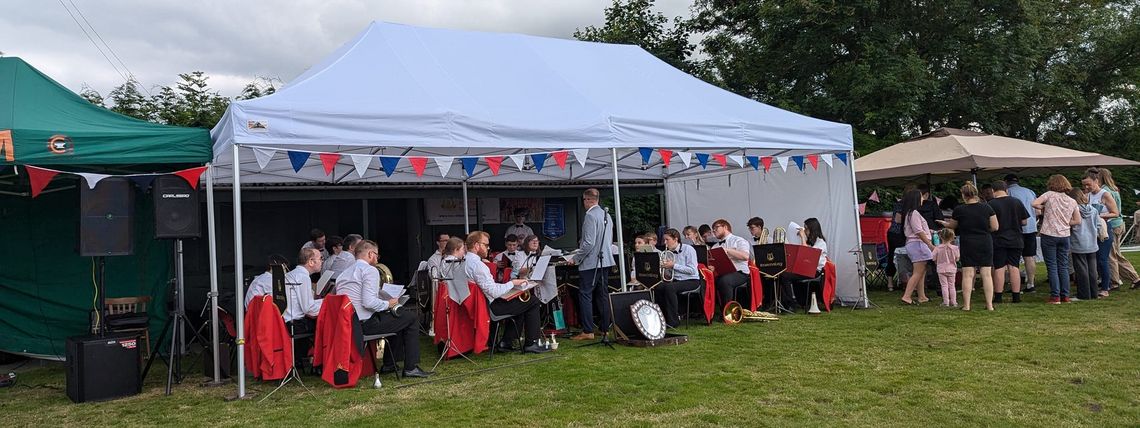 A brass band inside a large pop up gazebo